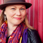 Image of Amy Morse wearing a hat and vibrant scarf
